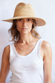 Woman wearing a straw hat against a white background