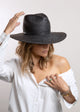 Model wearing black brimmed Panama hat with black trim