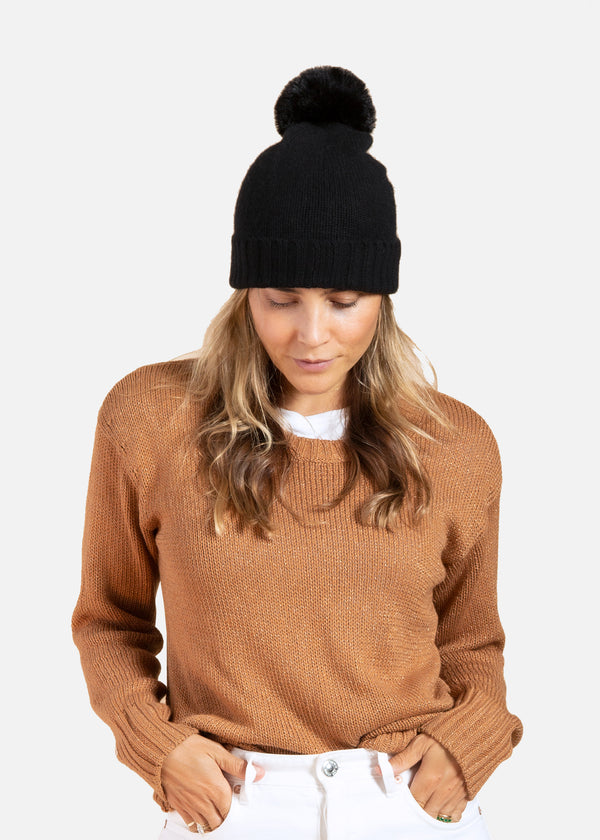 Black cashmere slouchy cuffed beanie with faux fur pom on model