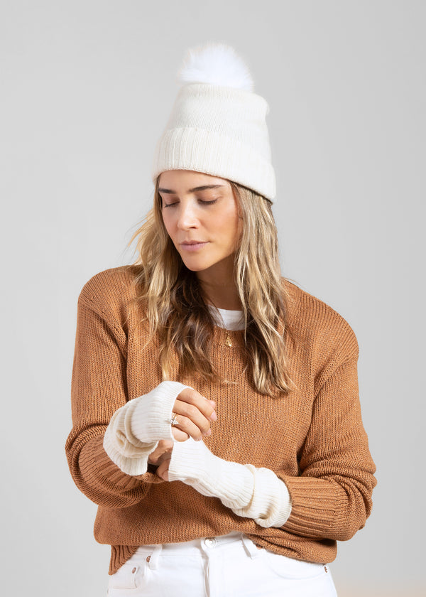 Ivory cashmere slouchy cuffed beanie with faux fur pom on model