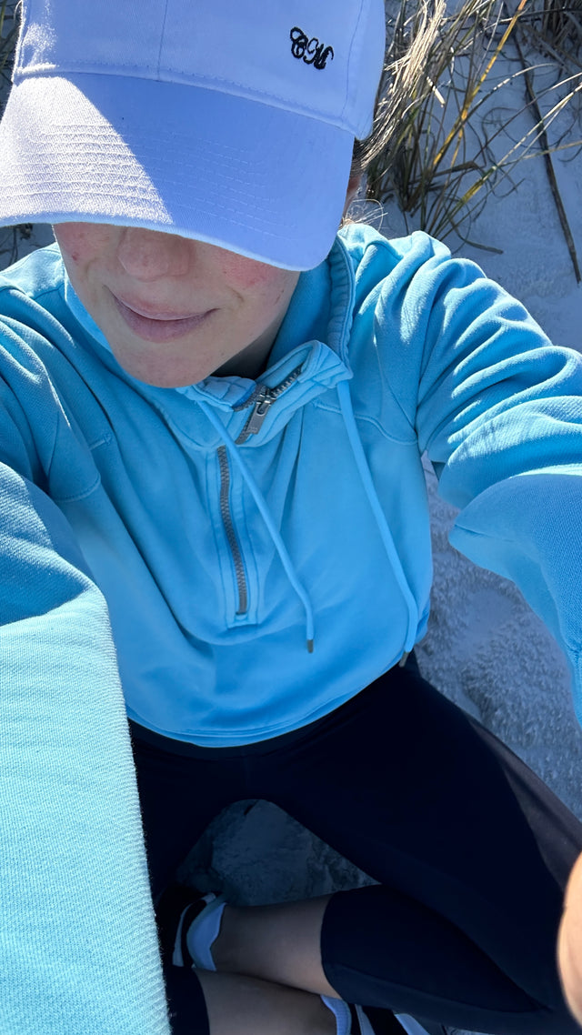 White baseball cap with embroidery on model at beach