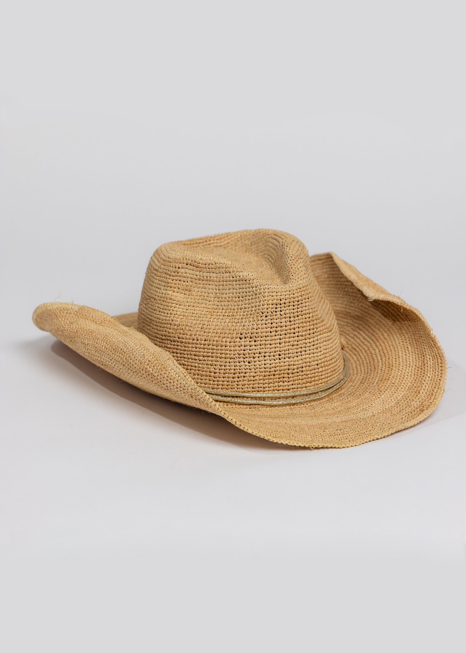 3/4 angle of raffia straw cowboy hat with metallic gold wrap detail