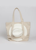 Tan canvas tote bag with white sun hat attached 