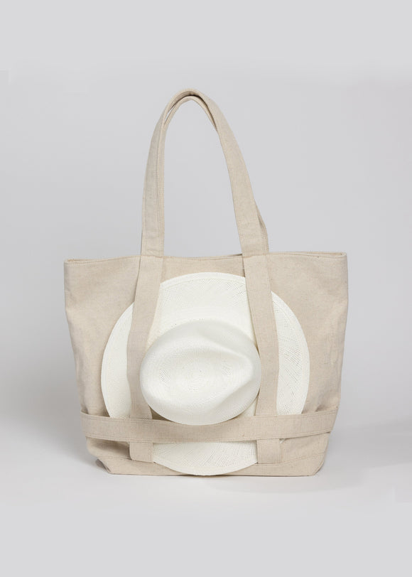 Tan canvas tote bag with white sun hat attached