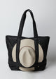 Hat attached to black quilted nylon bag with straps to hold a hat