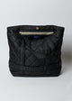 Inside zipper and snap of black quilted nylon bag with straps to hold a hat