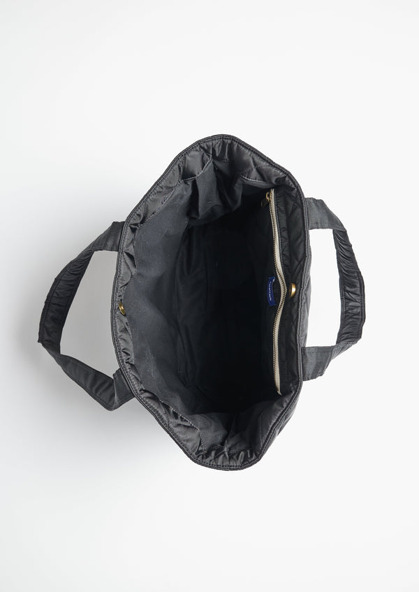 Inside of black quilted nylon bag with straps to hold a hat