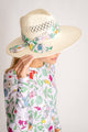 Model wearing white sunhat with colorful floral trim