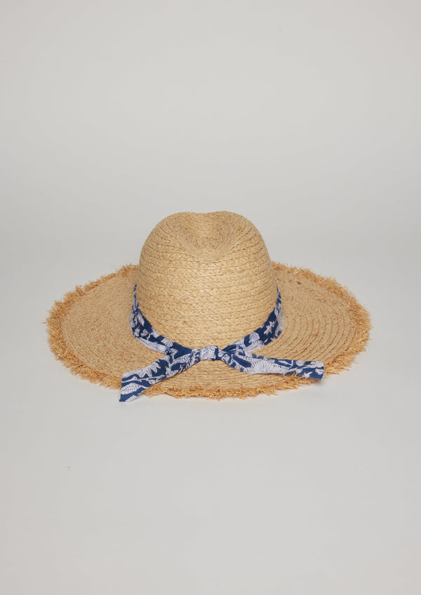 Back view of straw hat with fringe detail on brim and blue floral fabric trim