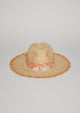 Front view of straw hat with fringe detail on brim and orange floral fabric trim