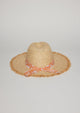 Back view of straw hat with fringe detail on brim and orange floral fabric trim