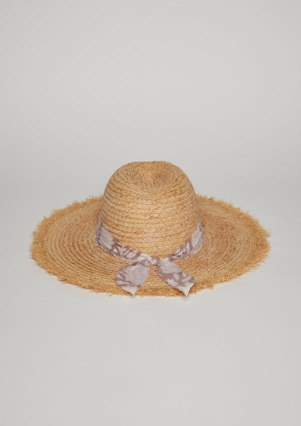 Straw hat with fringe detail on brim and tan floral fabric trim