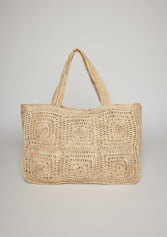Tan straw tote with intricate design pattern