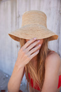 Model holding brim of straw bucket hat