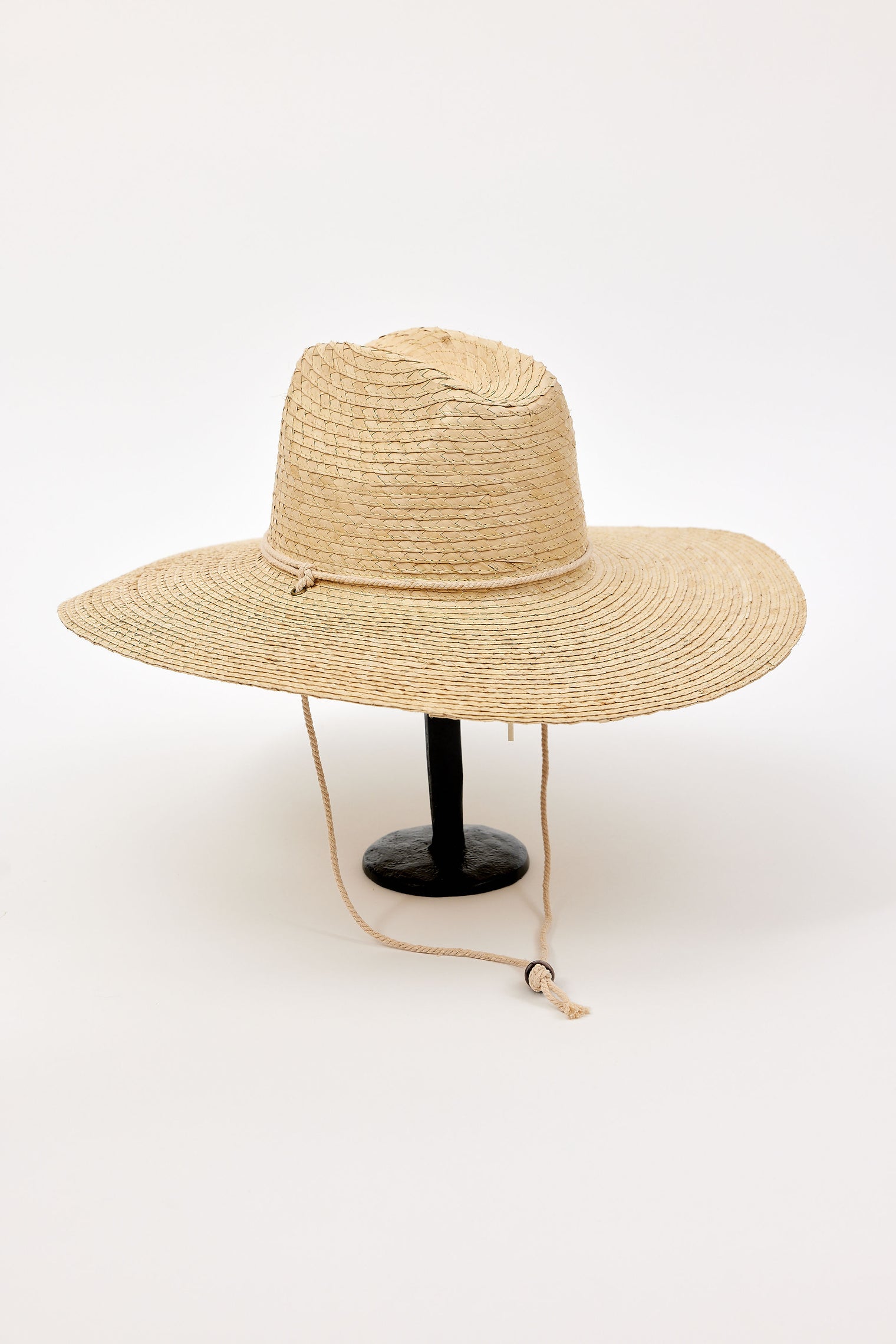 Beige straw hat with a chinstrap on a white background