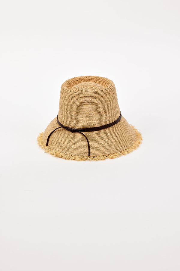 Beige straw bucket hat with a black band on a light beige background