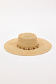 Beige straw hat with a wide brim and beaded trim detail on a white background