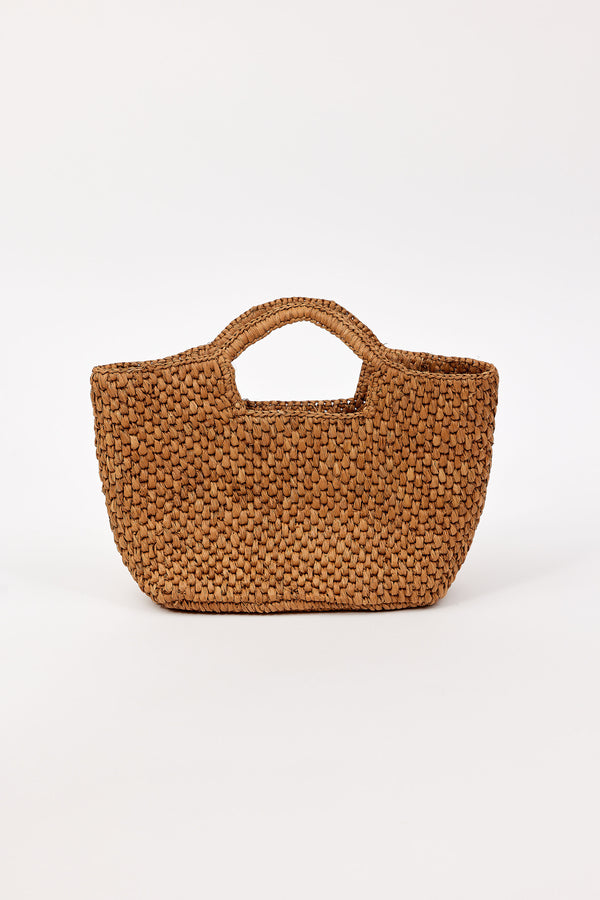 Brown straw woven handbag on a white background