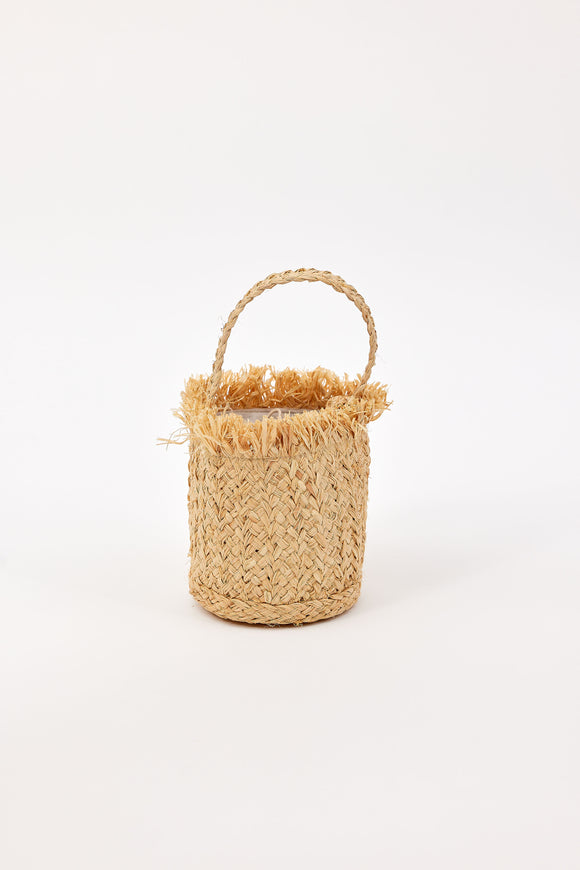 Woven mini bag with fringe detail and handle on a white background