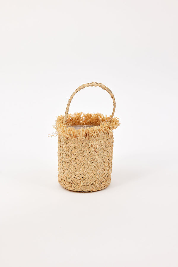Woven mini bag with fringe detail and handle on a white background