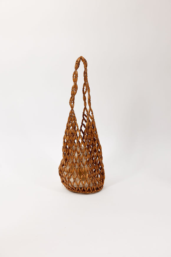 Woven brown beaded bag on a white background