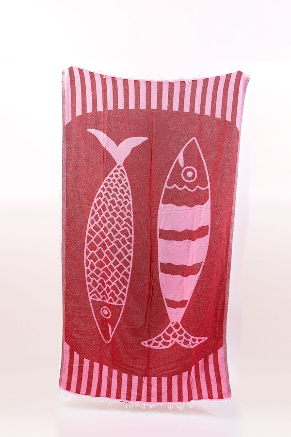 Red towel with white fish design and striped border on a white background