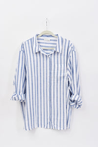 Blue and white striped shirt on a hanger against a white background