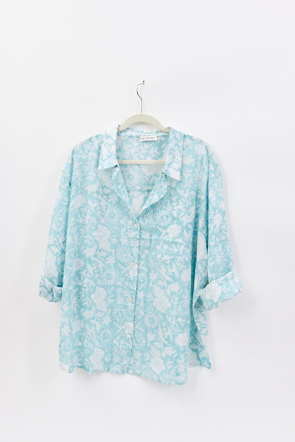 Light blue floral shirt on a hanger against a white background