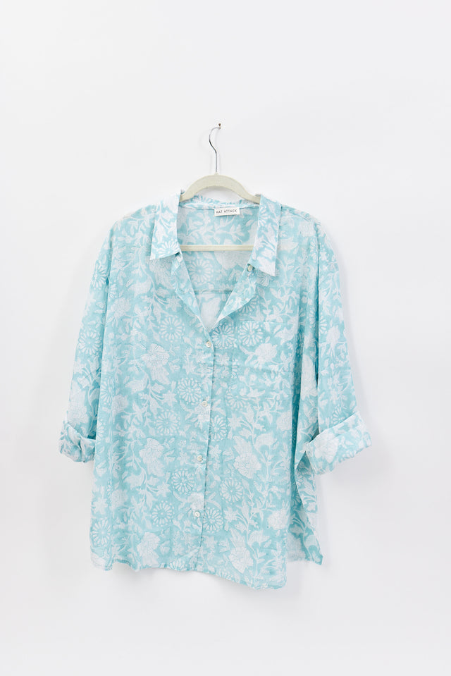Light blue floral shirt on a hanger against a white background