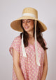 Model wearing large brimmed hat with ivory ribbon tie