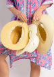 Model holding three sun hats showing they have adjustable sweat bands