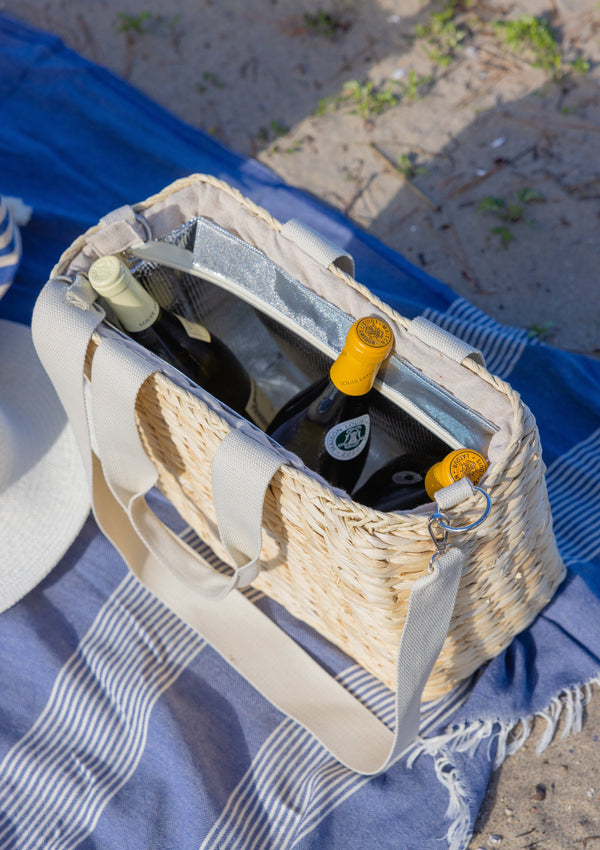 Straw cooler tote at the beach on a blue blanket