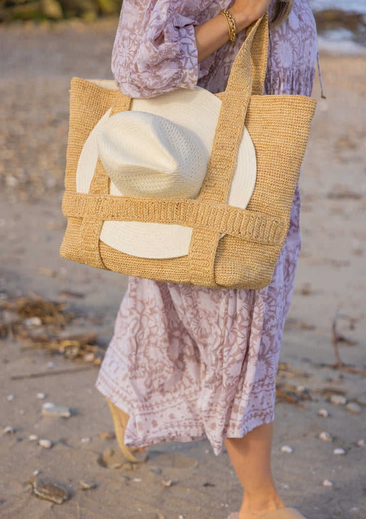 Perforated and Vented Packable hat in bleach attached to beach bag