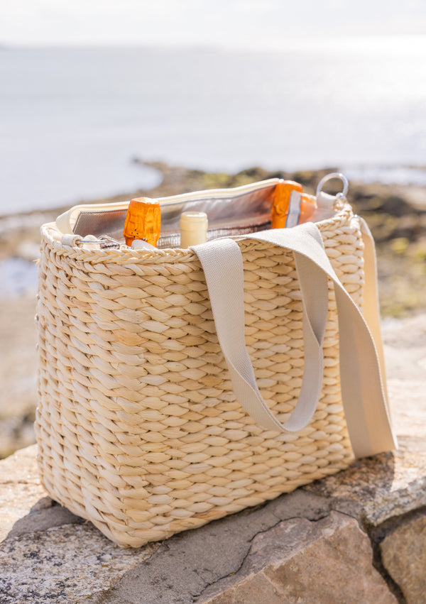 Straw cooler tote with wine bottles inside