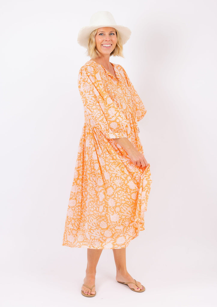 Coral floral beach dress on model in sandals and sunhat