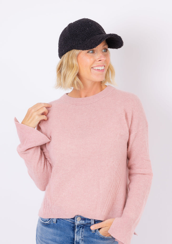 Sherpa Cap in black on model in pink sweater looking to her left