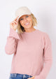 Sherpa Cap in parchment on model in pink sweater holding brim