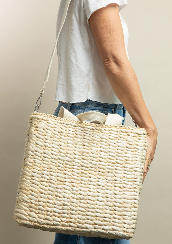 Model holding straw cooler tote over shoulder