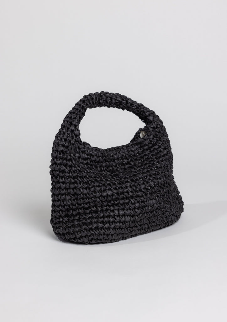 3/4 angle of slouchy raffia straw bag in black